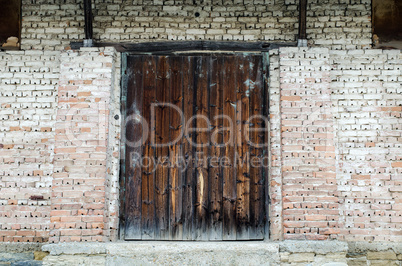 Old wooden gate at brick building