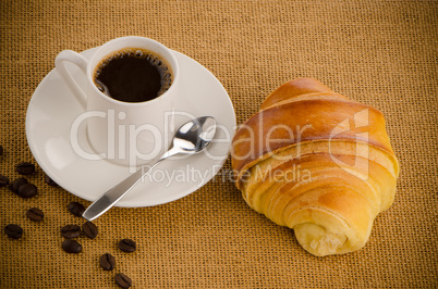 Cup of black coffee and croissant