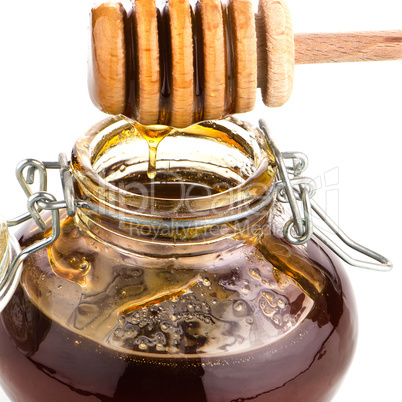 Jar of honey with wooden drizzler