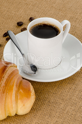 Cup of black coffee and croissant