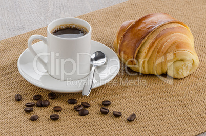 Cup of black coffee and croissant