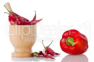 Red chili and bell pepper on wooden mortar