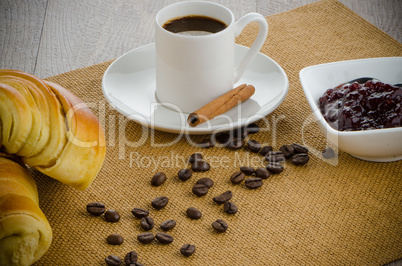 Cup of black coffee and croissant