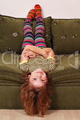 little girl lying upside down on the bed