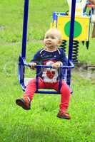 baby plays on the swing