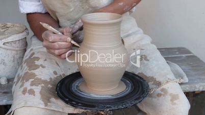 potter painting a clay jug