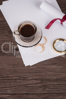 Coffee cup, paper sheets and detective hat