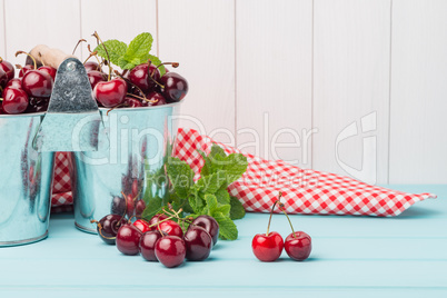 Cherries in two small metal buckets