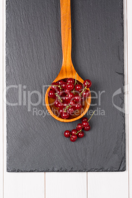 Currants in a wooden spoon