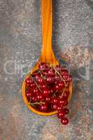 Currants in a wooden spoon