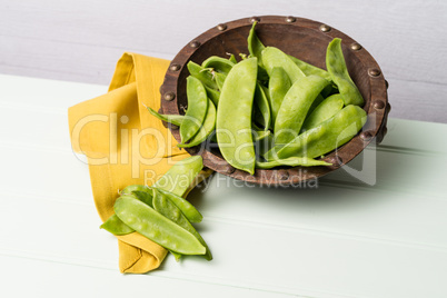 Snow peas on wooden bowl