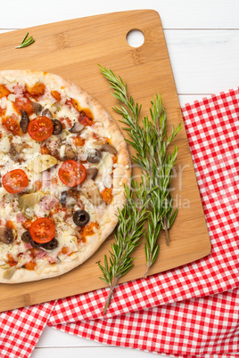 Pizza with bacon, olives and tomato