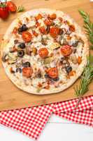 Pizza with bacon, olives and tomato