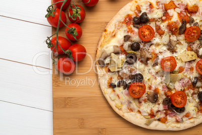 Pizza with bacon, olives and tomato