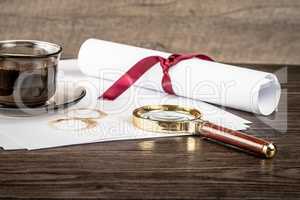 Coffee cup, paper sheets and detective magnifying glass