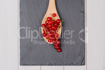 Currants in a wooden spoon