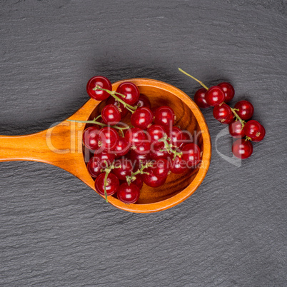 Currants in a wooden spoon