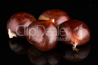 Chestnuts on a black reflective background