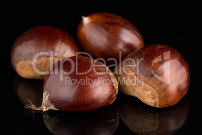 Chestnuts on a black reflective background