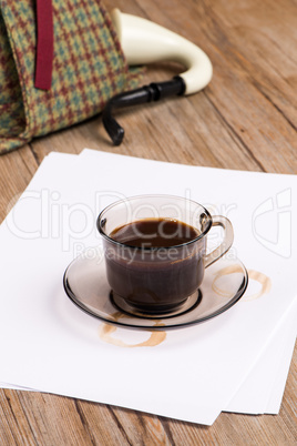 Coffee cup, paper sheets and detective hat