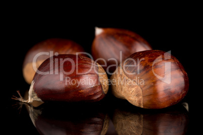 Chestnuts on a black reflective background