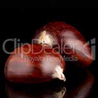 Chestnuts on a black reflective background