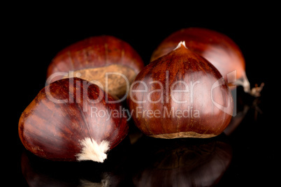 Chestnuts on a black reflective background