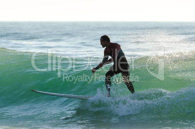 Long boarder surfing the waves at sunset