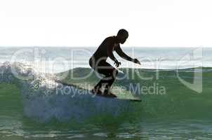 Long boarder surfing the waves at sunset