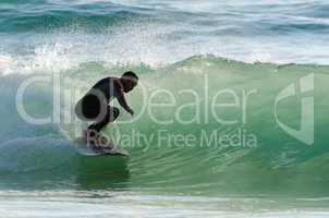 Long boarder surfing the waves at sunset