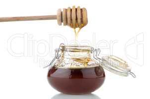 Jar of honey with wooden drizzler