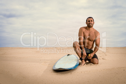 Surfer tying his surfboard's leach