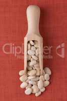 Wooden scoop with white beans