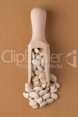 Wooden scoop with white beans