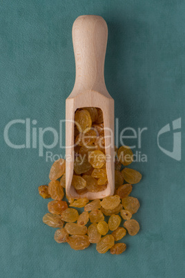 Wooden scoop with golden raisins