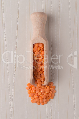 Wooden scoop with  peeled lentils