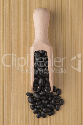 Wooden scoop with black beans