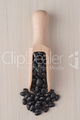 Wooden scoop with black beans