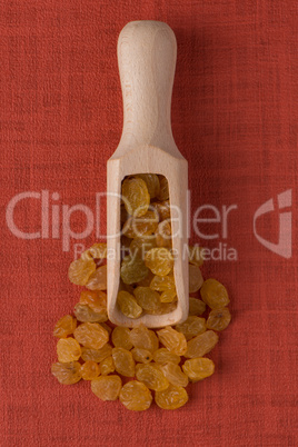 Wooden scoop with golden raisins