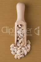 Wooden scoop with white beans