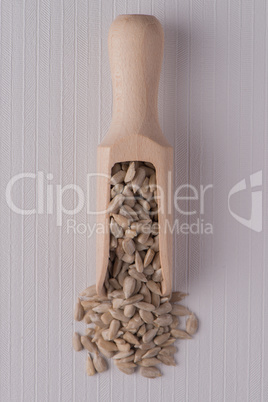 Wooden scoop with shelled sunflower seeds