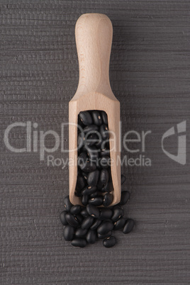 Wooden scoop with black beans