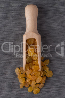 Wooden scoop with golden raisins