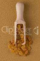 Wooden scoop with golden raisins