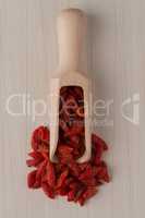 Wooden scoop with dry red goji berries