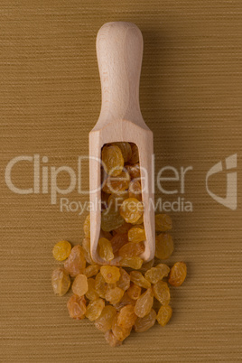 Wooden scoop with golden raisins