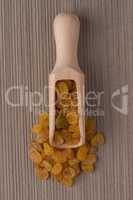 Wooden scoop with golden raisins