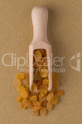 Wooden scoop with golden raisins