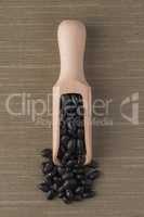 Wooden scoop with black beans