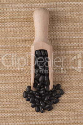 Wooden scoop with black beans